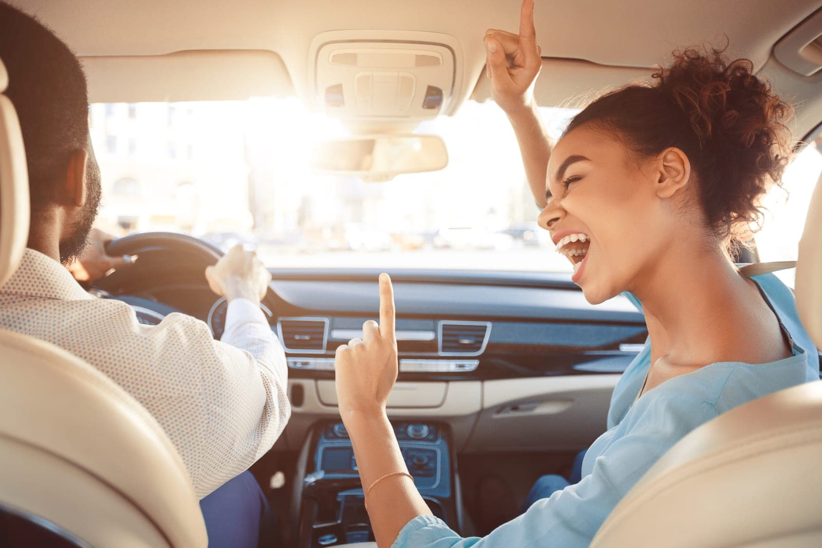 A couple singing along to music while driving